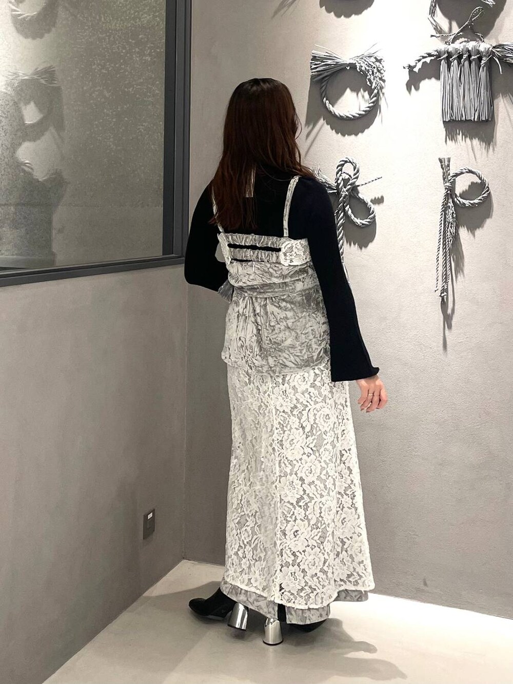 ブラック系のニット/セーター、ブラック系のブーツ、グレー系のベストを着用したレディースの秋コーディネートの2枚目の写真