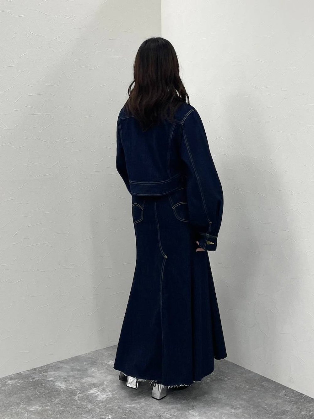 ブルー系のデニムジャケット、ブラック系のブーツ、ブルー系のデニムスカートを着用したレディースの秋コーディネートの4枚目の写真