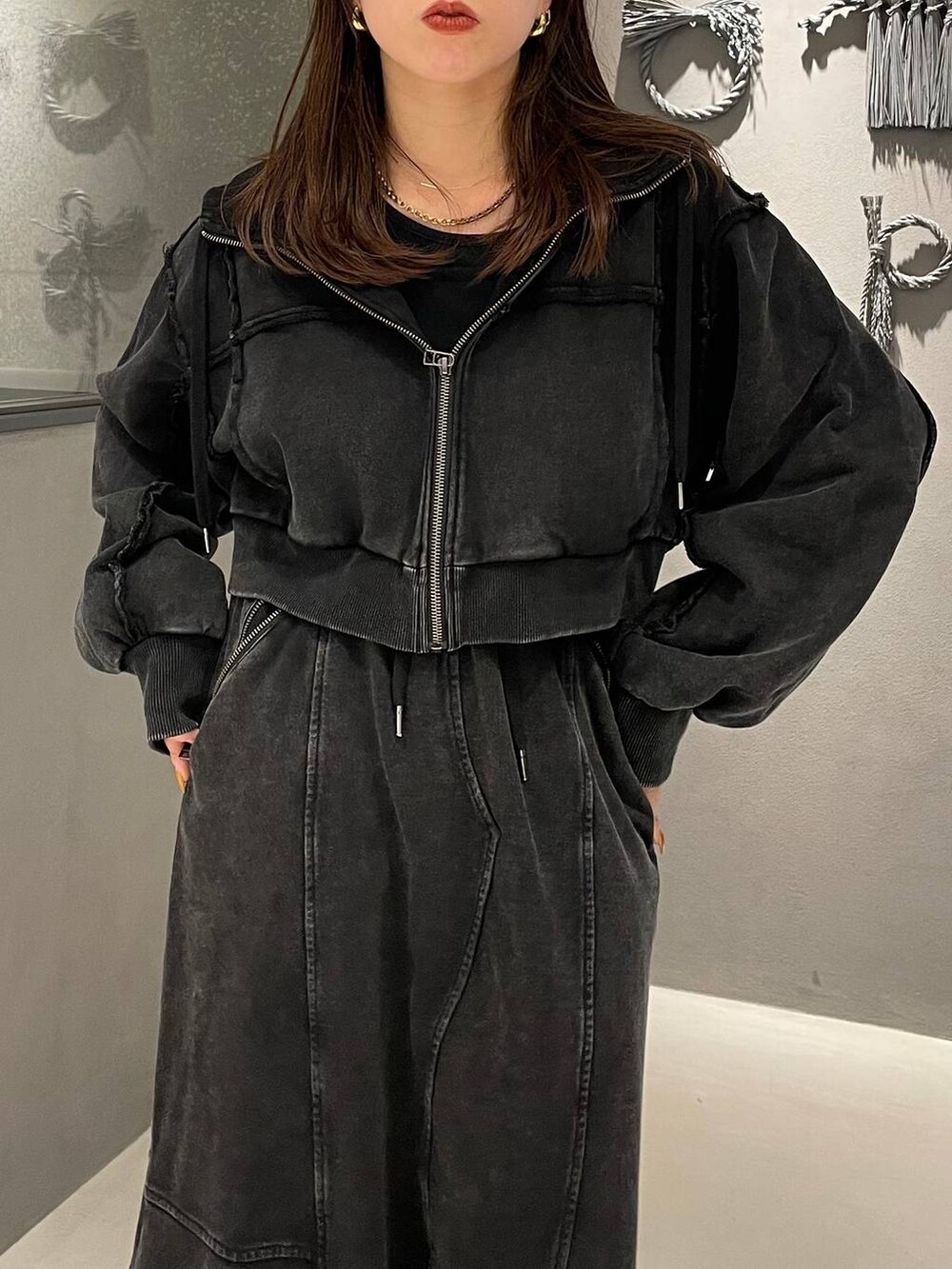 ブラック系のタンクトップ、ブラック系のブーツ、ブラック系のスカートを着用したレディースの秋コーディネートの4枚目の写真