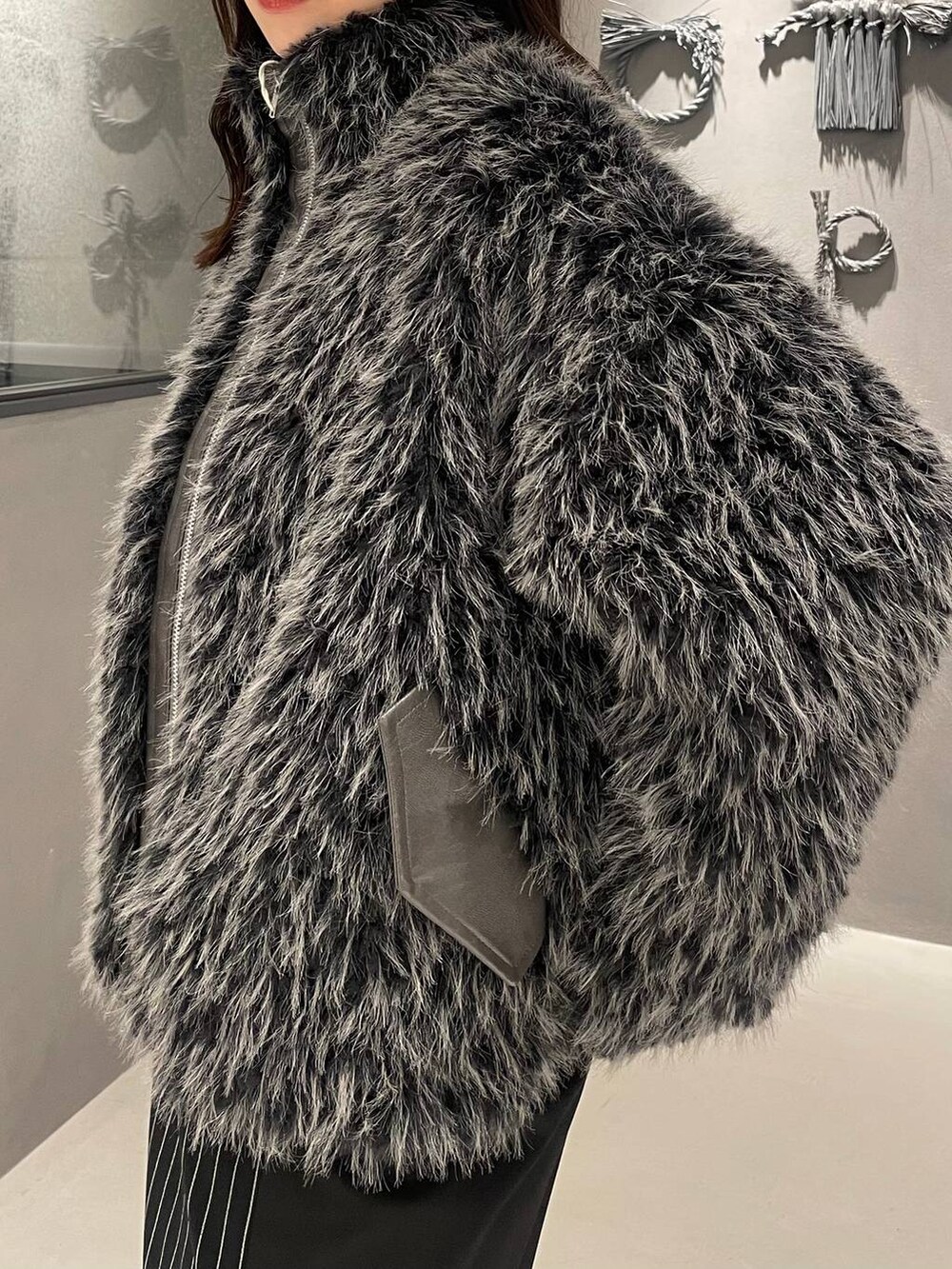 ブラック系のブーツ、グレー系のブルゾン、ブラック系のスカートを着用したレディースの秋コーディネートの5枚目の写真