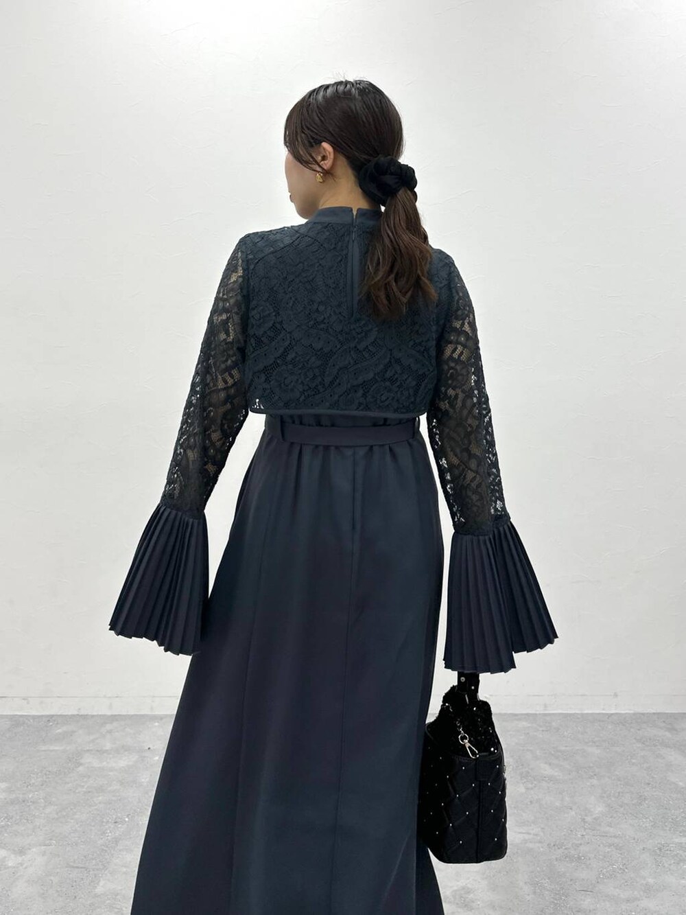 ブラック系のブーツ、ブラック系のショルダーバッグ、ブルー系のドレスを着用したレディースの夏コーディネートの6枚目の写真