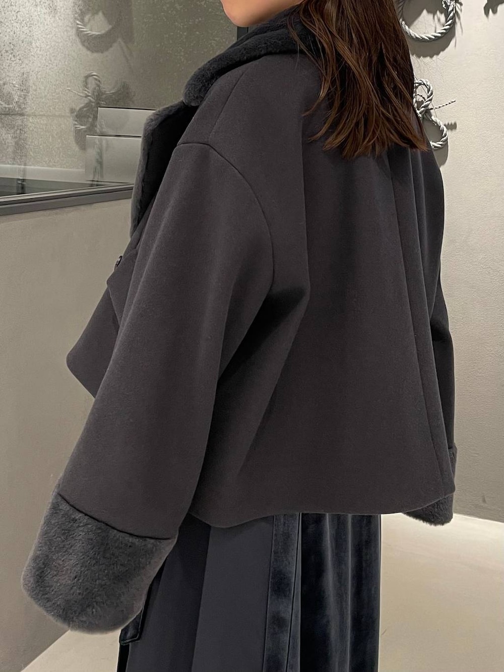 ブルー系のワンピース、ブラック系のブーツ、グレー系のその他アウターを着用したレディースの冬コーディネートの8枚目の写真