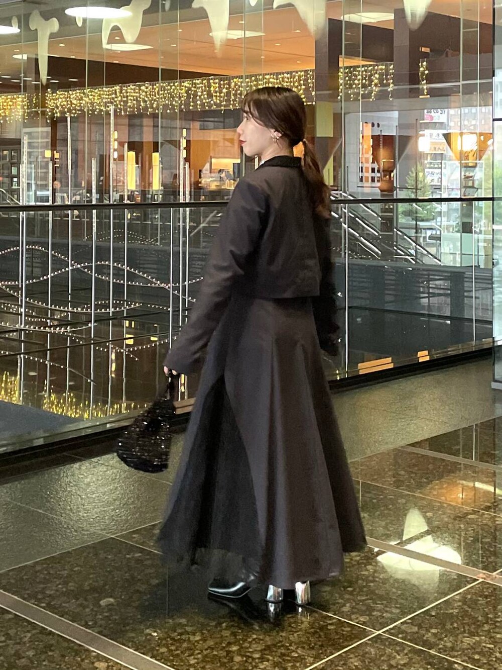 ブラック系のブーツ、グレー系のドレスを着用したレディースの秋コーディネートの3枚目の写真