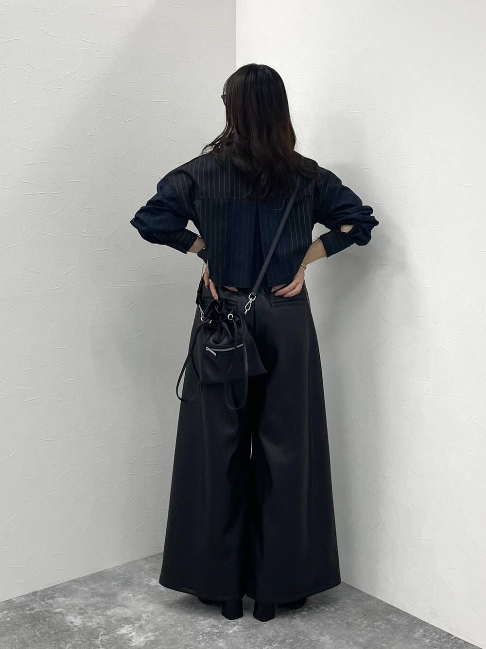 ブラック系のその他パンツ、ブラック系のブーツ、ブラック系のショルダーバッグを着用したレディースの秋コーディネートの4枚目の写真