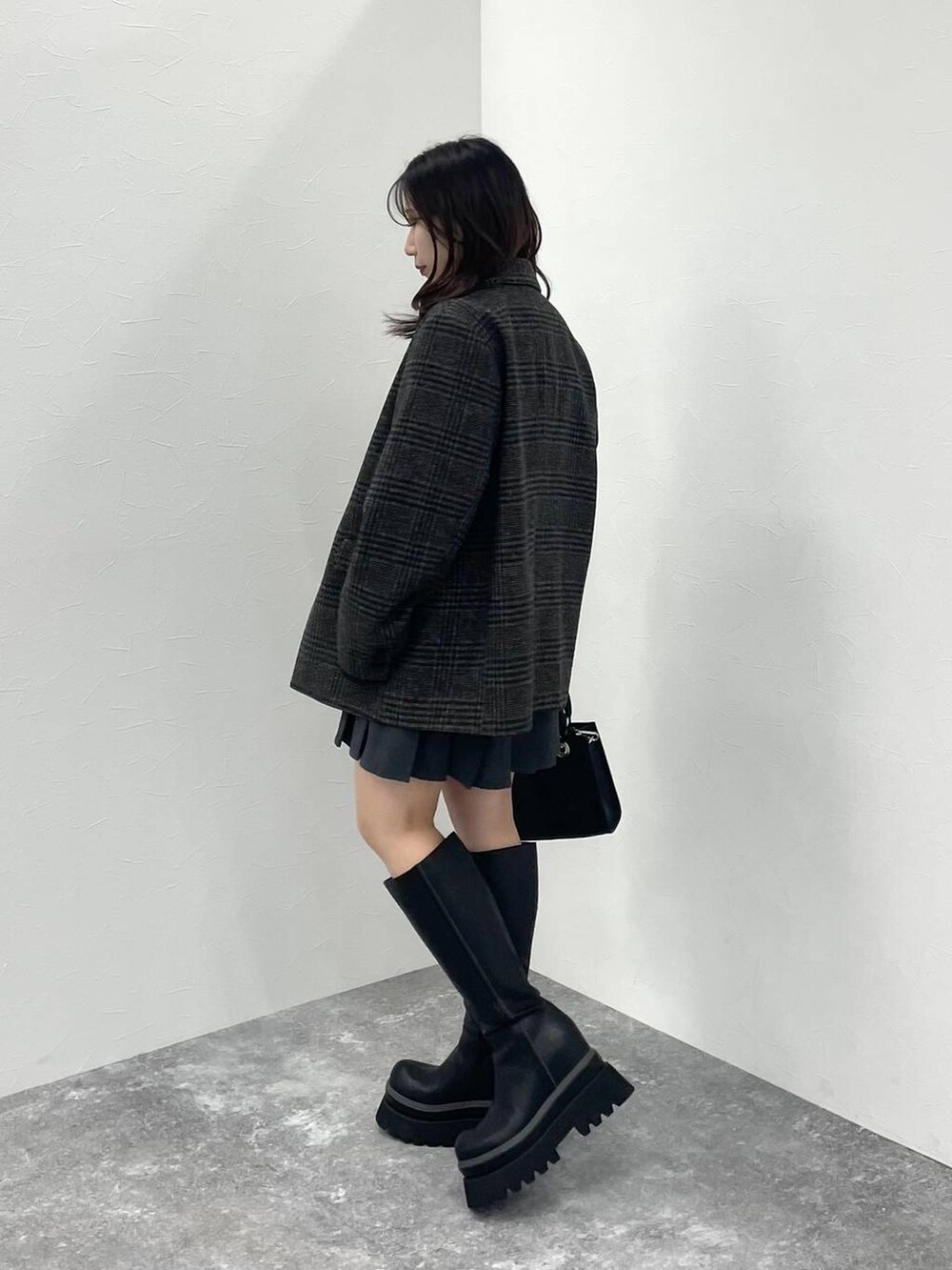 ブラック系のTシャツ/カットソー、ブラック系のショルダーバッグ、ブラック系のブーツを着用したレディースの秋コーディネートの2枚目の写真