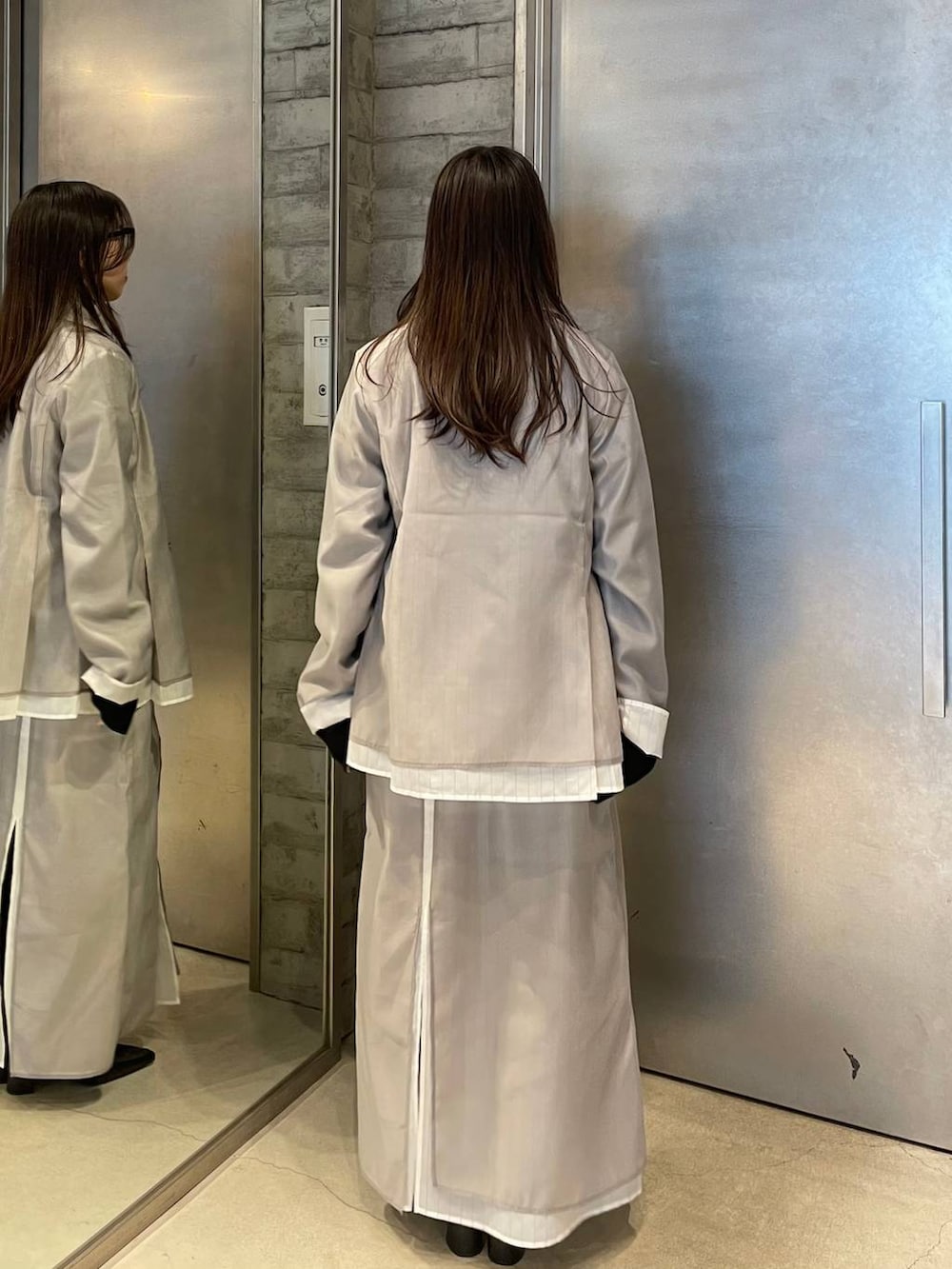 ブラック系のサンダル、ベージュ系のスカート、ベージュ系のテーラードジャケットを着用したレディースの春コーディネートの3枚目の写真