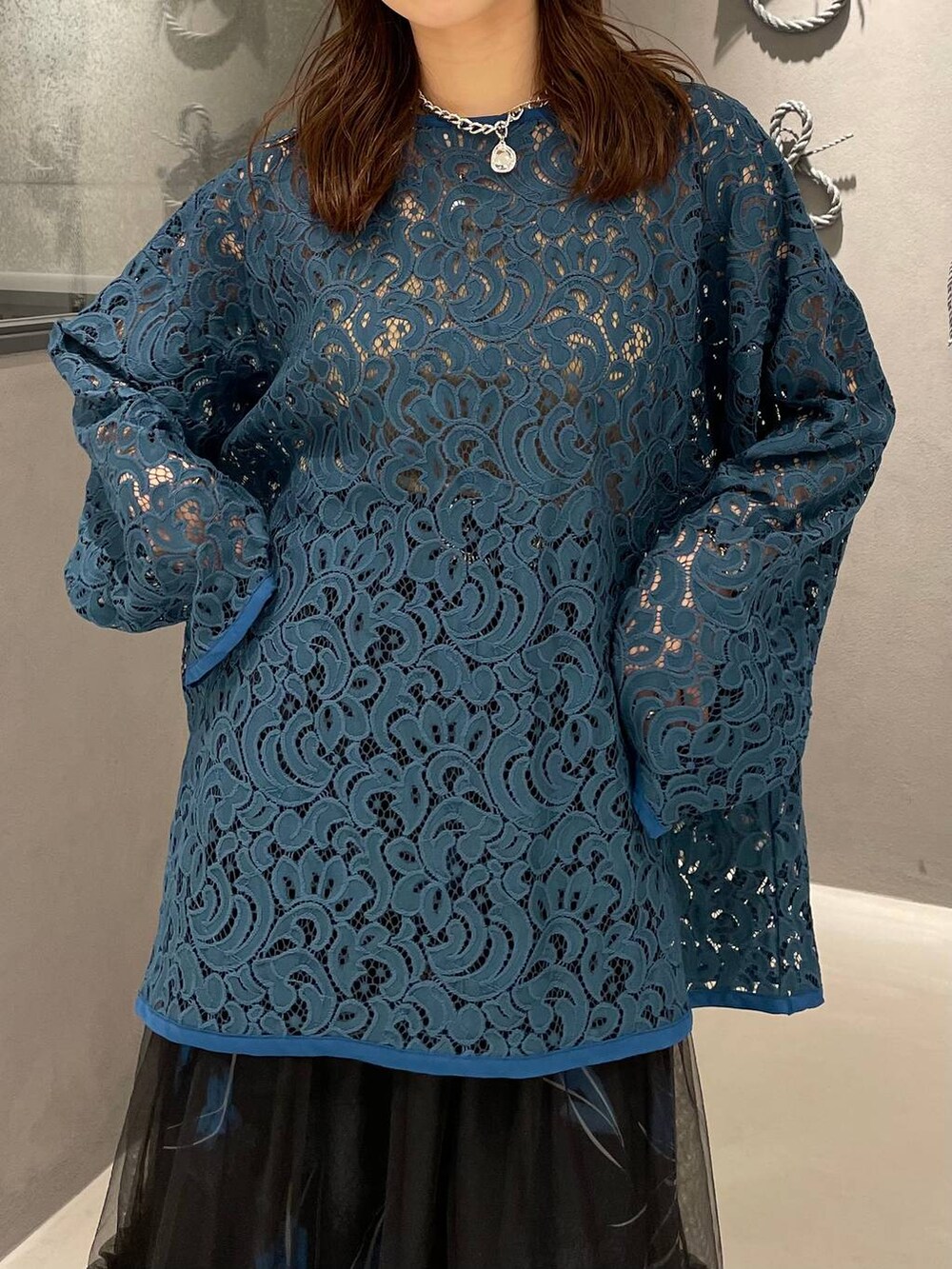 ブラック系のパンプス、ブラック系のスカート、グリーン系のTシャツ/カットソーを着用したレディースの春コーディネートの4枚目の写真