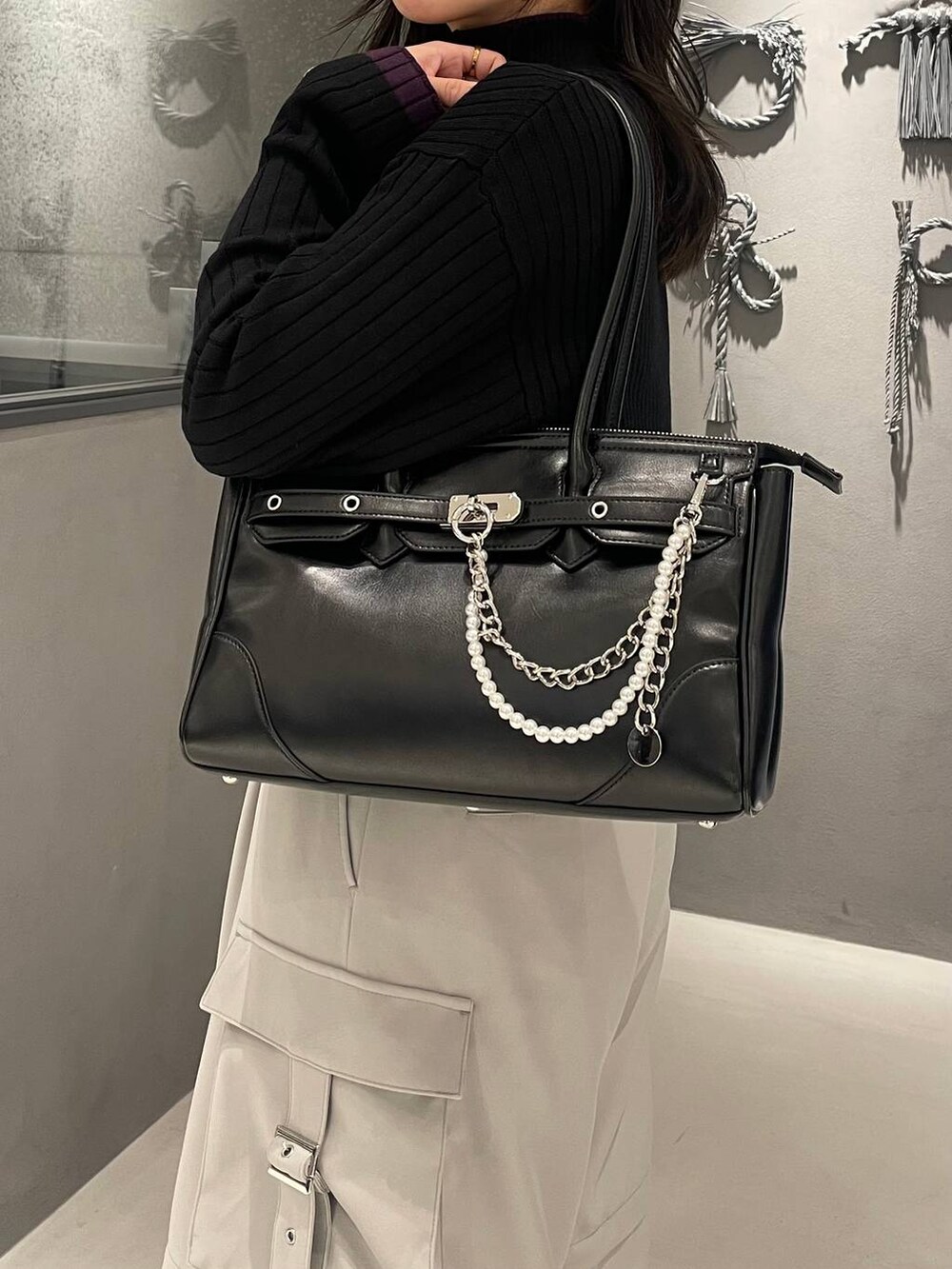 ホワイト系のカーゴパンツ、ブラック系のブーツ、ブラック系のボストンバッグを着用したレディースの冬コーディネートの6枚目の写真