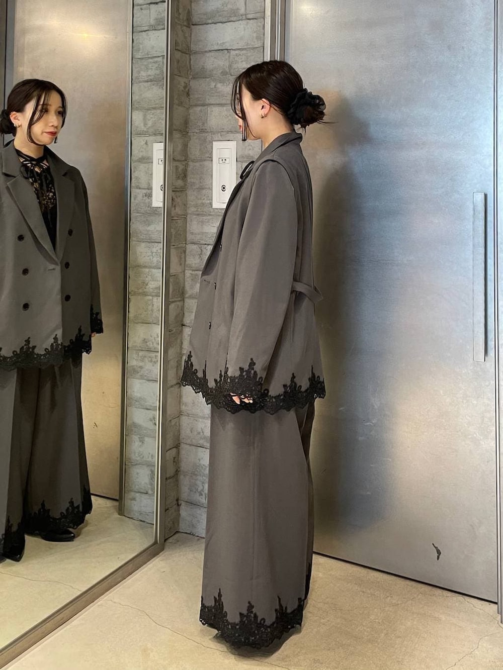 ブラック系のパンプス、グレー系のスラックス、グレー系のテーラードジャケットを着用したレディースの冬コーディネートの2枚目の写真