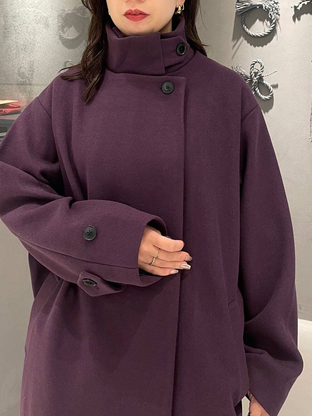 パープル系のチェスターコート、ブラック系のブーツ、レッド系のニット/セーターを着用したレディースの秋コーディネートの4枚目の写真