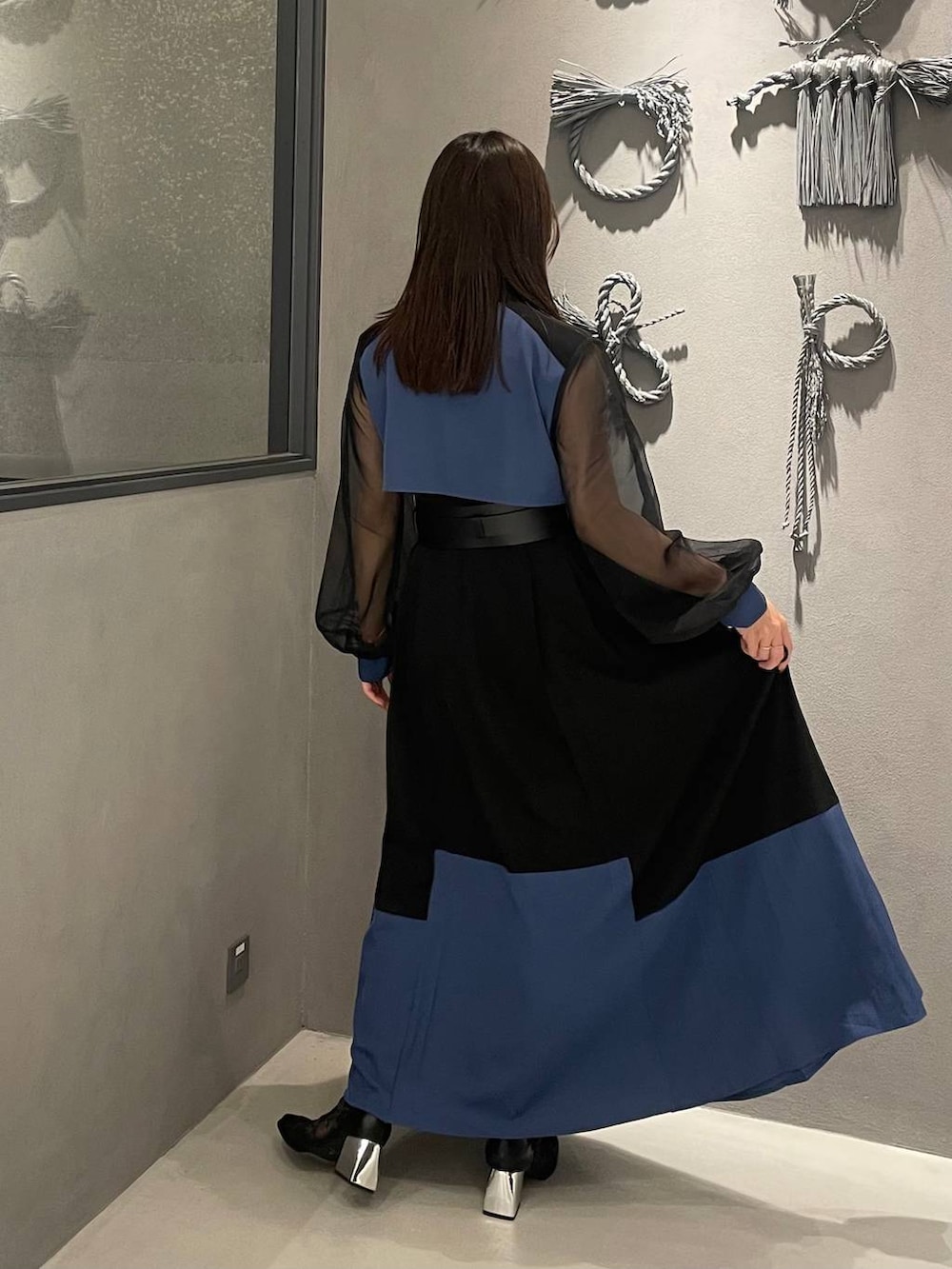 ブラック系のブーツ、ブラック系のワンピース、ブラック系のベルトを着用したレディースの夏コーディネートの2枚目の写真