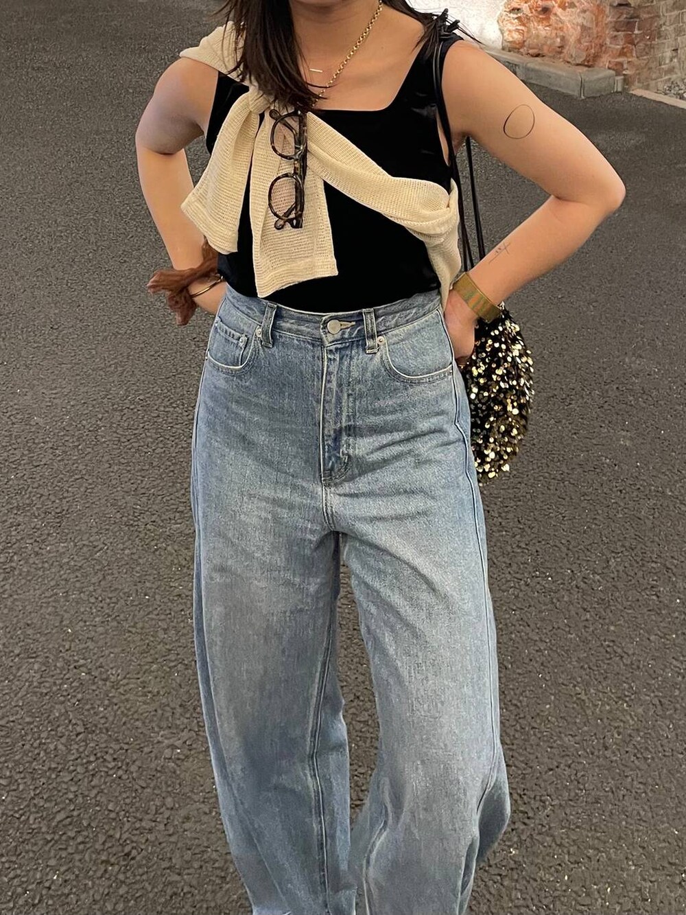 ブルー系のデニムパンツ、ブラック系のサンダルを着用したレディースの秋コーディネートの3枚目の写真