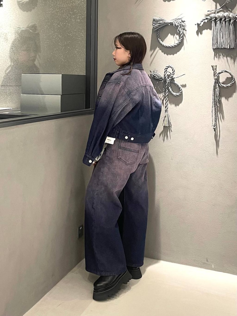 ホワイト系のスウェット、パープル系のデニムジャケット、パープル系のデニムパンツを着用したレディースの冬コーディネートの2枚目の写真