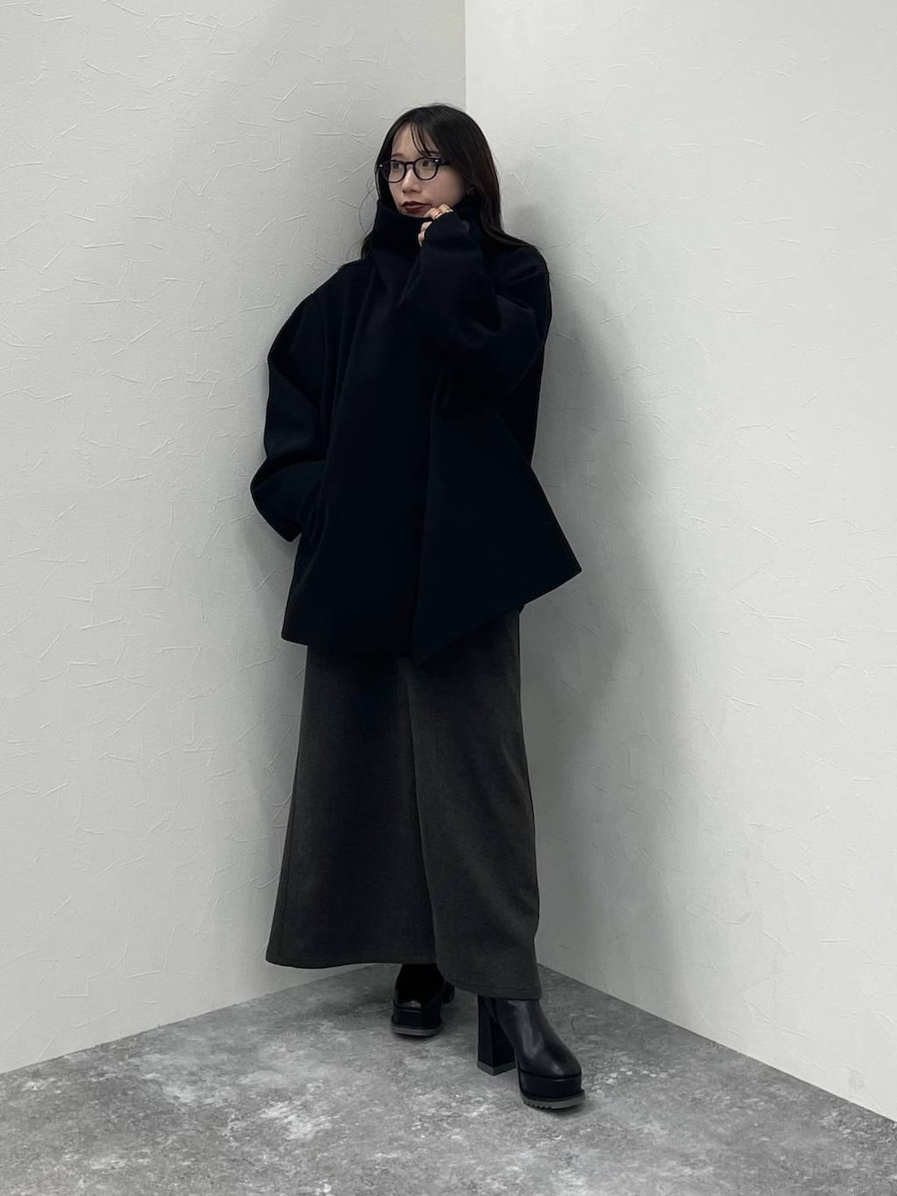 ブラック系のチェスターコート、グレー系のニット/セーター、ブラック系のブーツを着用したレディースの秋コーディネートの4枚目の写真