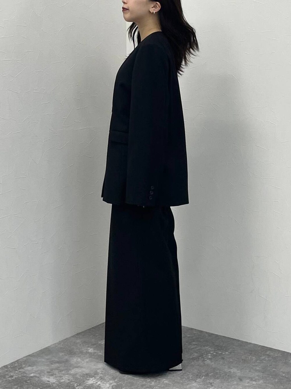 ブラック系のブーツ、ブラック系のノーカラージャケット、ブラック系のスラックスを着用したレディースの秋コーディネートの3枚目の写真