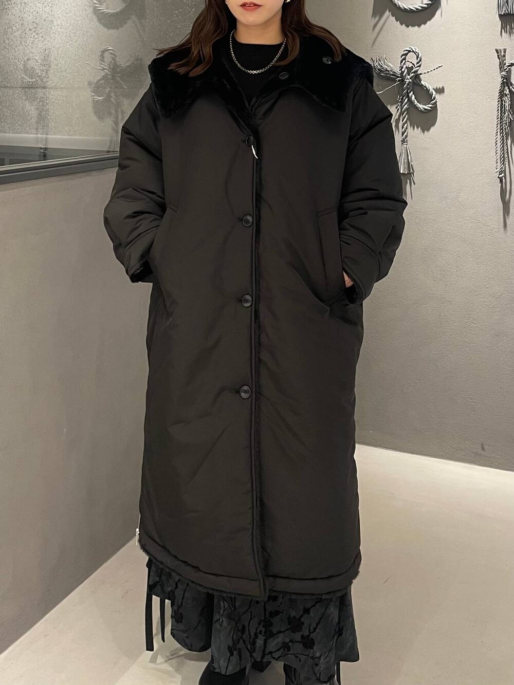 ブラック系のダウンジャケット/コート、ブラック系のブーツ、ブラック系のニット/セーターを着用したレディースの秋コーディネートの4枚目の写真