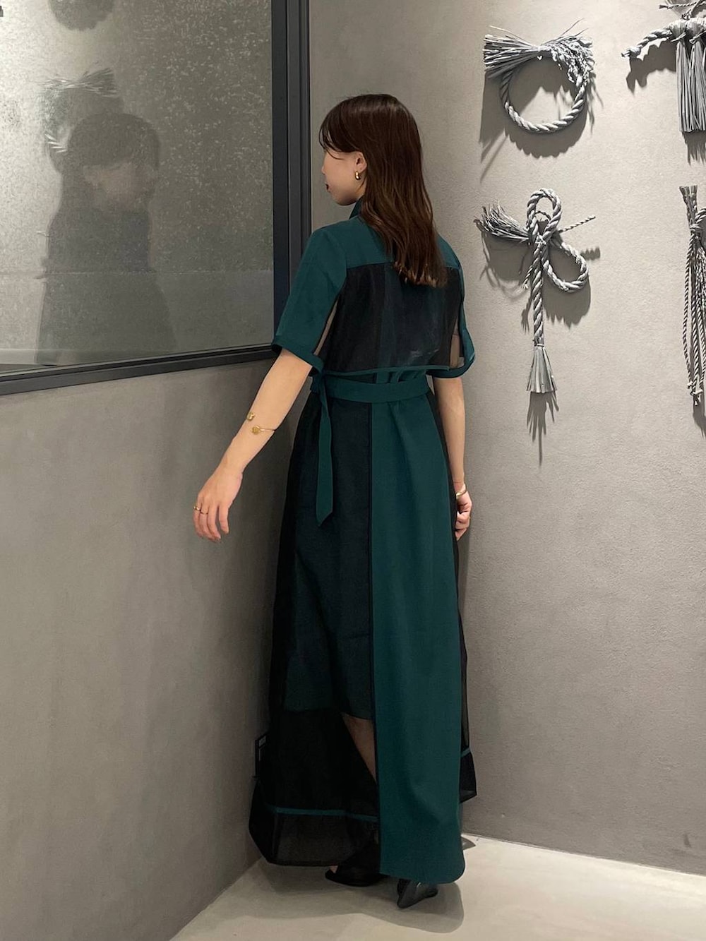 ブラック系のサンダル、グリーン系のワンピースを着用したレディースの夏コーディネートの3枚目の写真