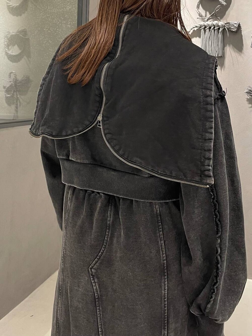 ブラック系のタンクトップ、ブラック系のブーツ、ブラック系のスカートを着用したレディースの秋コーディネートの5枚目の写真