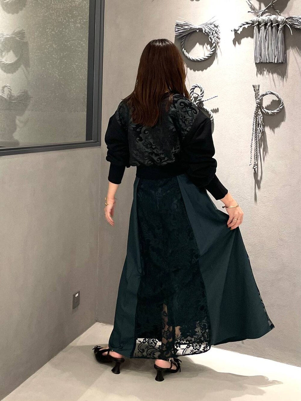 ブラック系のパンプス、グリーン系のスカート、グリーン系のスウェットを着用したレディースの夏コーディネートの2枚目の写真