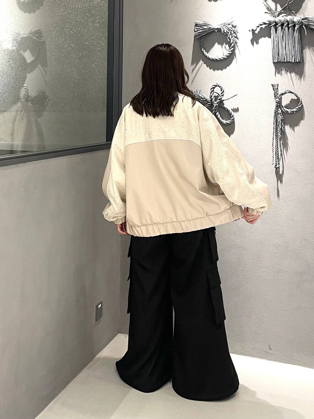 グレー系のニット/セーター、ブラック系のバレエシューズ、ブラック系のカーゴパンツを着用したレディースの秋コーディネートの3枚目の写真