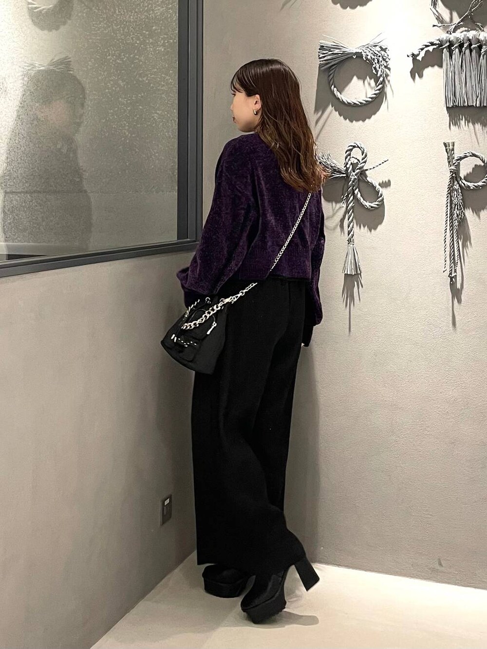 ブラック系のショルダーバッグ、ブラック系のブーツ、パープル系のカーディガン/ボレロを着用したレディースの秋コーディネートの2枚目の写真