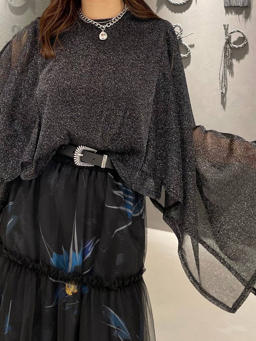 ブラック系のパンプス、ブラック系のスカート、ブラック系のTシャツ/カットソーを着用したレディースの春コーディネートの4枚目の写真