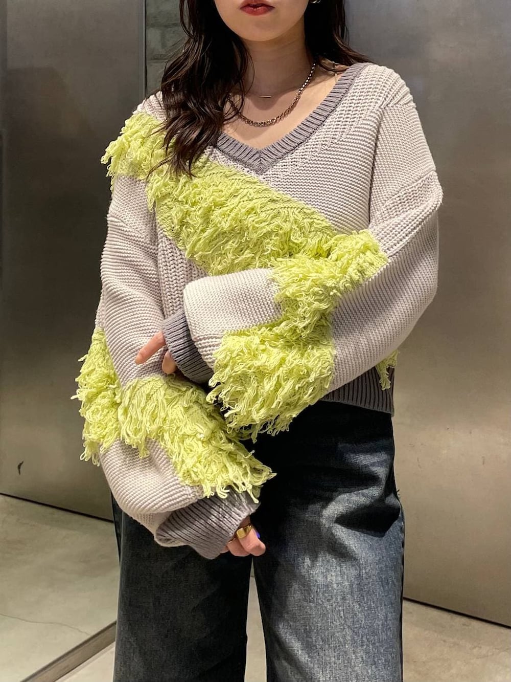 ブルー系のデニムパンツ、ブラック系のブーツ、イエロー系のニット/セーターを着用したレディースの冬コーディネートの4枚目の写真