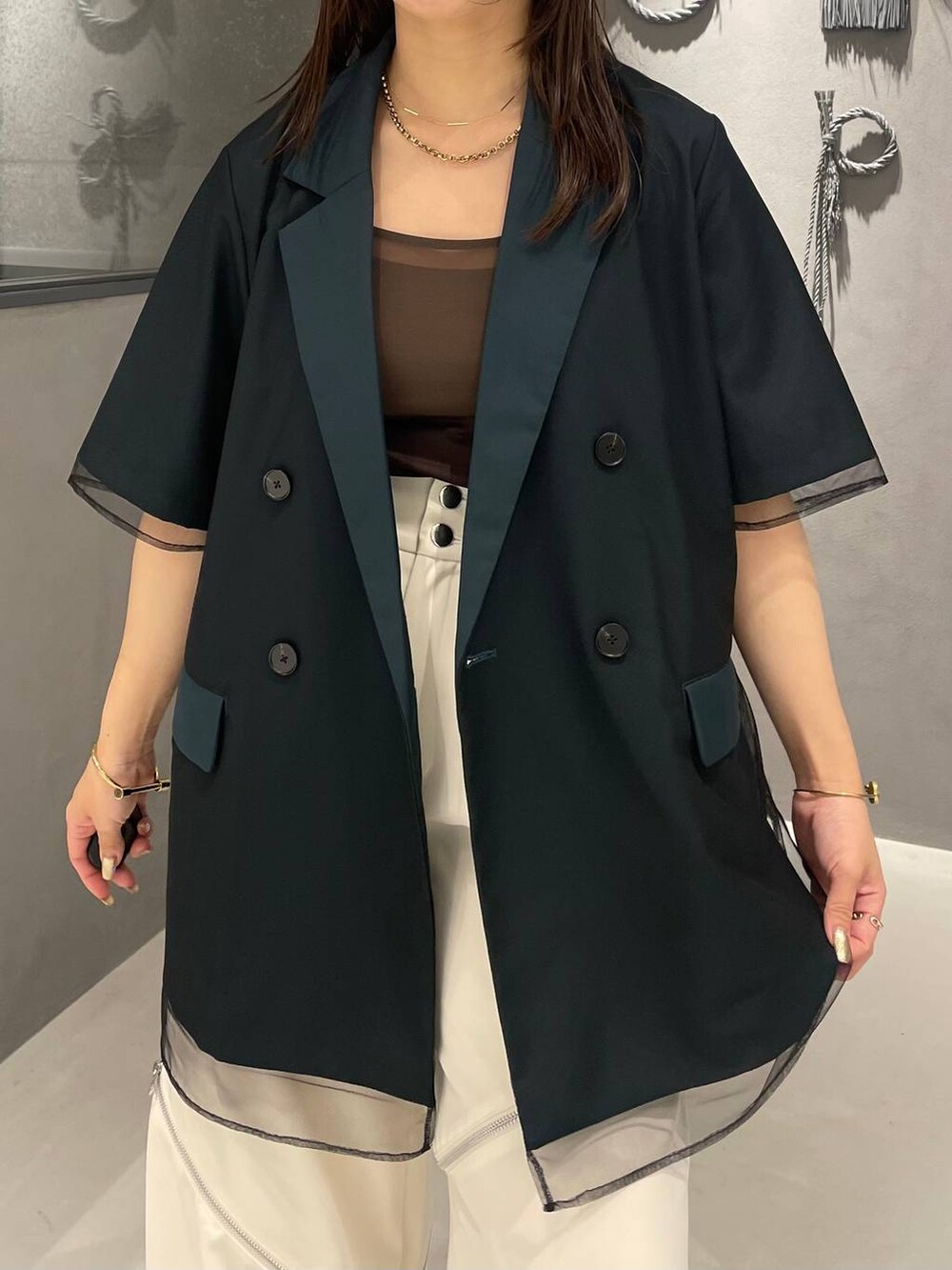 ブラック系のサンダル、ホワイト系のその他パンツ、グリーン系のテーラードジャケットを着用したレディースの夏コーディネートの4枚目の写真