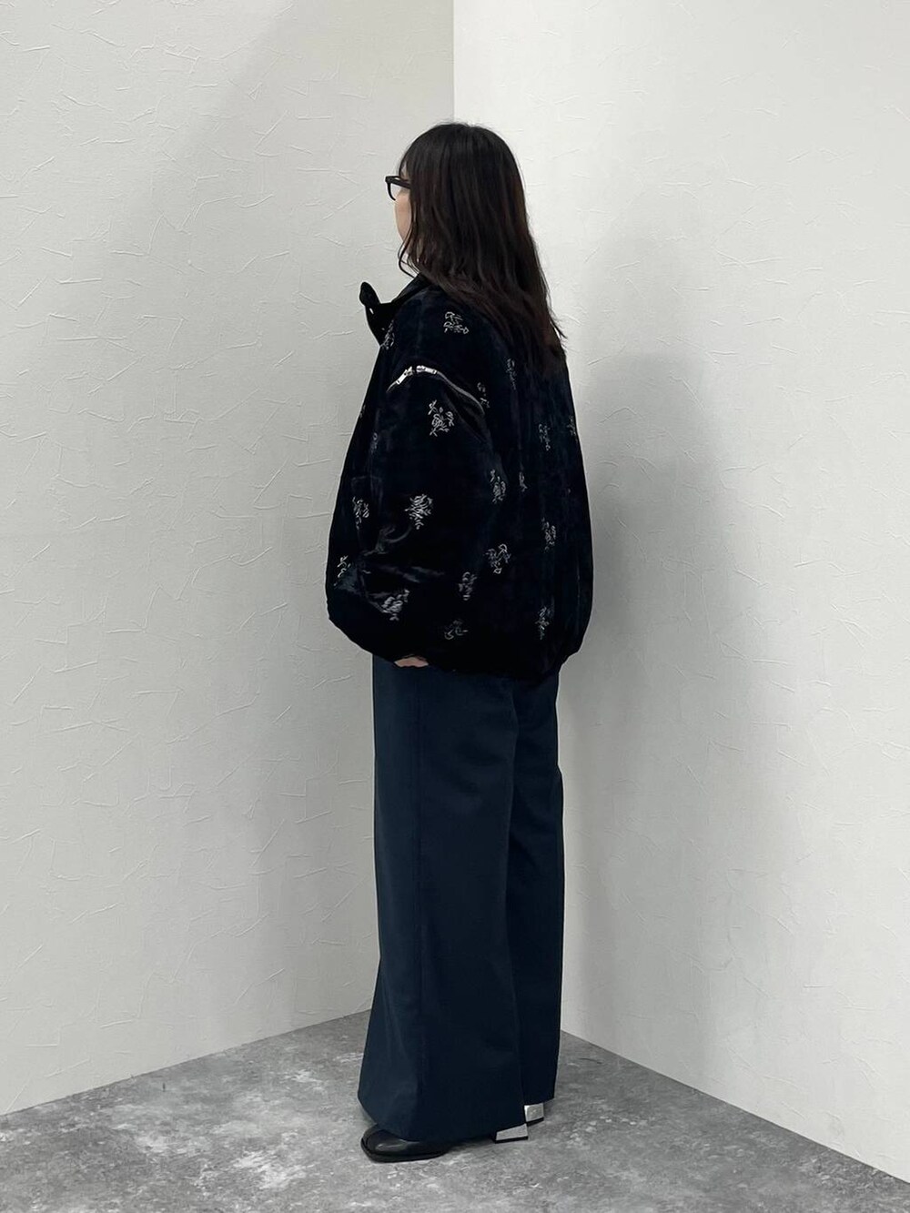 ブラック系のブルゾン、ブラック系のブーツ、ブラック系のスラックスを着用したレディースの秋コーディネートの2枚目の写真