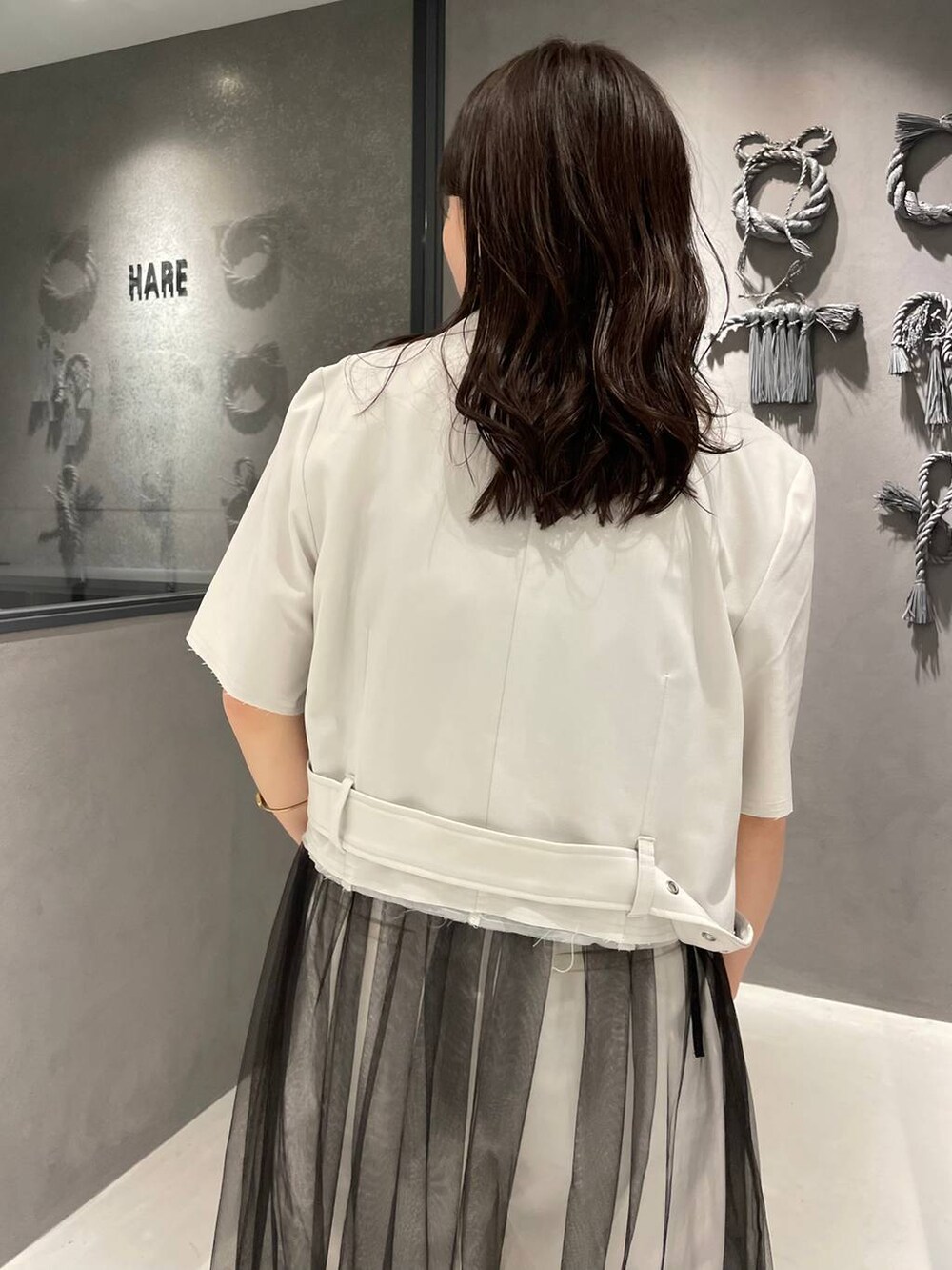 ブラック系のブーツ、ブラック系のタンクトップ、ブラック系のスカートを着用したレディースの夏コーディネートの4枚目の写真