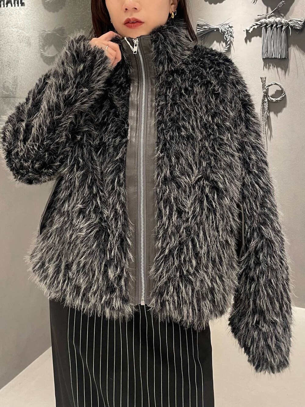 ブラック系のブーツ、グレー系のブルゾン、ブラック系のスカートを着用したレディースの秋コーディネートの4枚目の写真