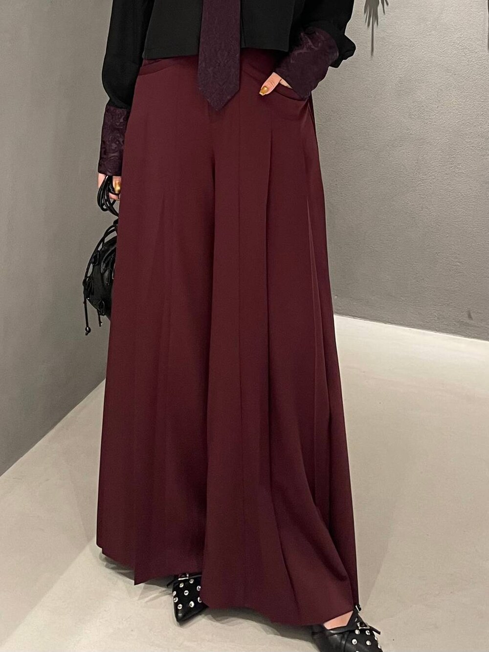 ブラック系のパンプス、ブラック系のショルダーバッグ、パープル系のシャツ/ブラウスを着用したレディースの夏コーディネートの6枚目の写真