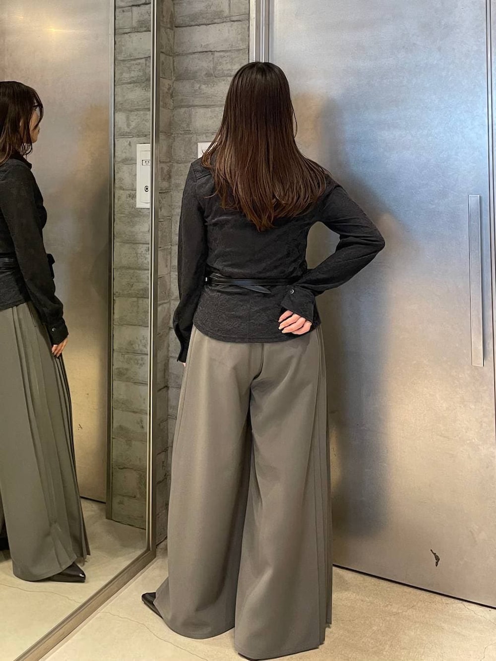 ブラック系のサンダル、ブラック系のボディバッグ/ウエストポーチ、グレー系のスラックスを着用したレディースの春コーディネートの4枚目の写真