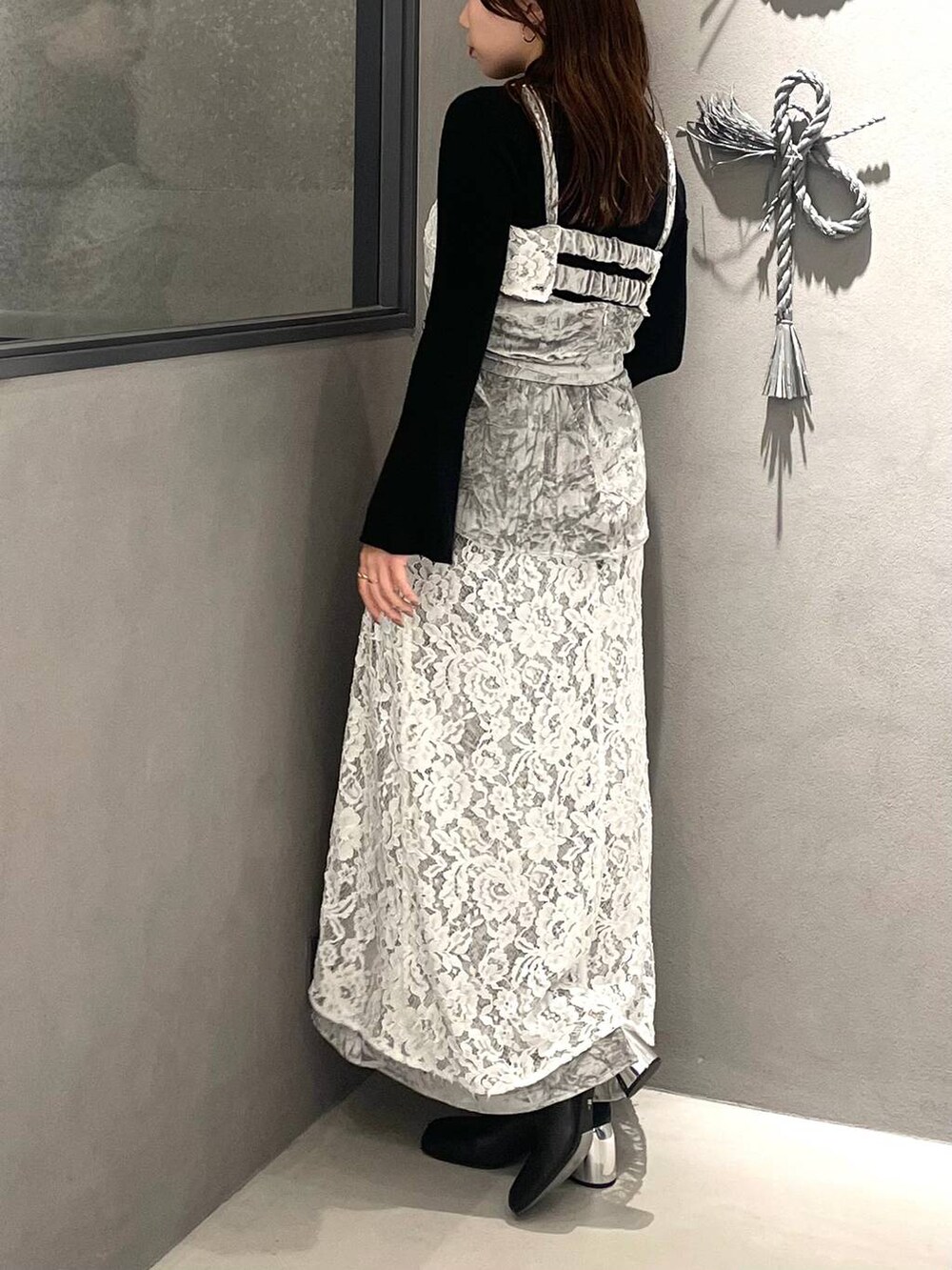 ブラック系のニット/セーター、ブラック系のブーツ、グレー系のベストを着用したレディースの秋コーディネートの4枚目の写真