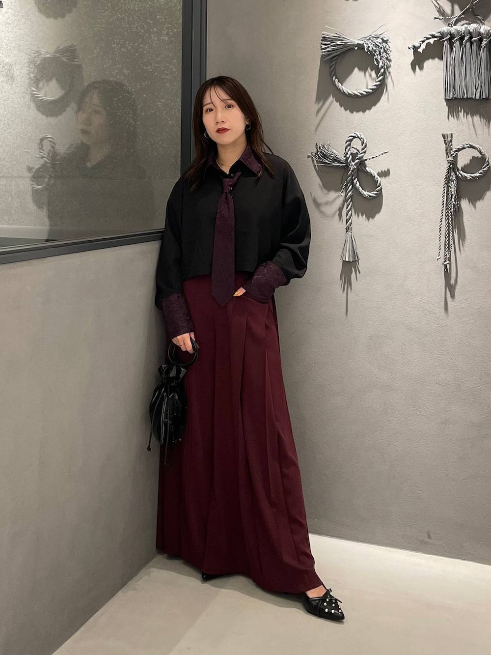 ブラック系のパンプス、ブラック系のショルダーバッグ、パープル系のシャツ/ブラウスを着用したレディースの夏コーディネートの2枚目の写真