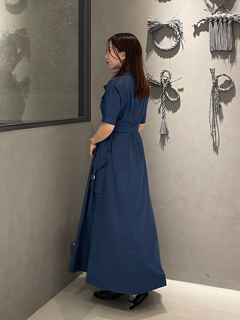 ブラック系のサンダル、ブルー系のワンピースを着用したレディースの春コーディネートの2枚目の写真