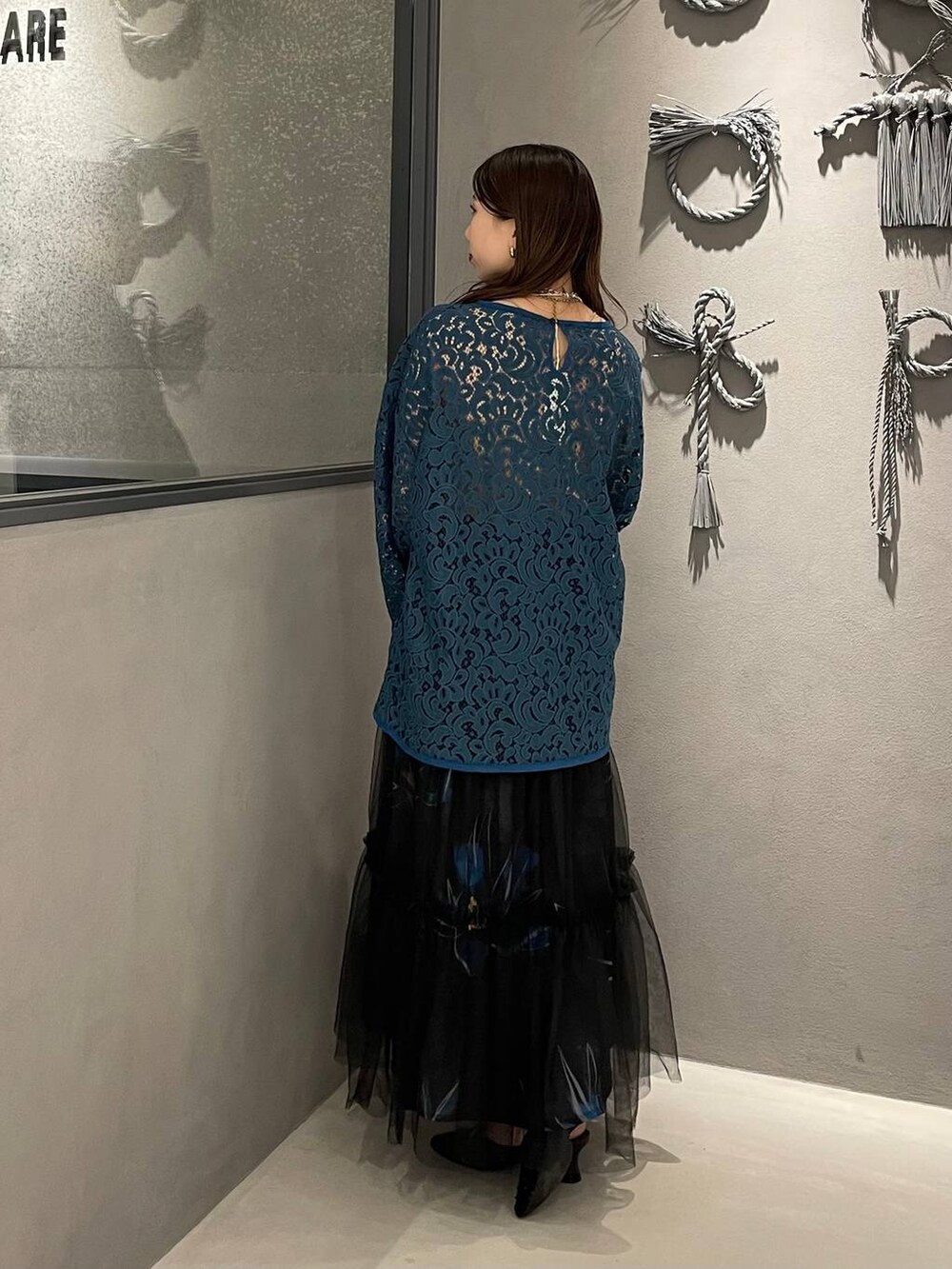 ブラック系のパンプス、ブラック系のスカート、グリーン系のTシャツ/カットソーを着用したレディースの春コーディネートの2枚目の写真