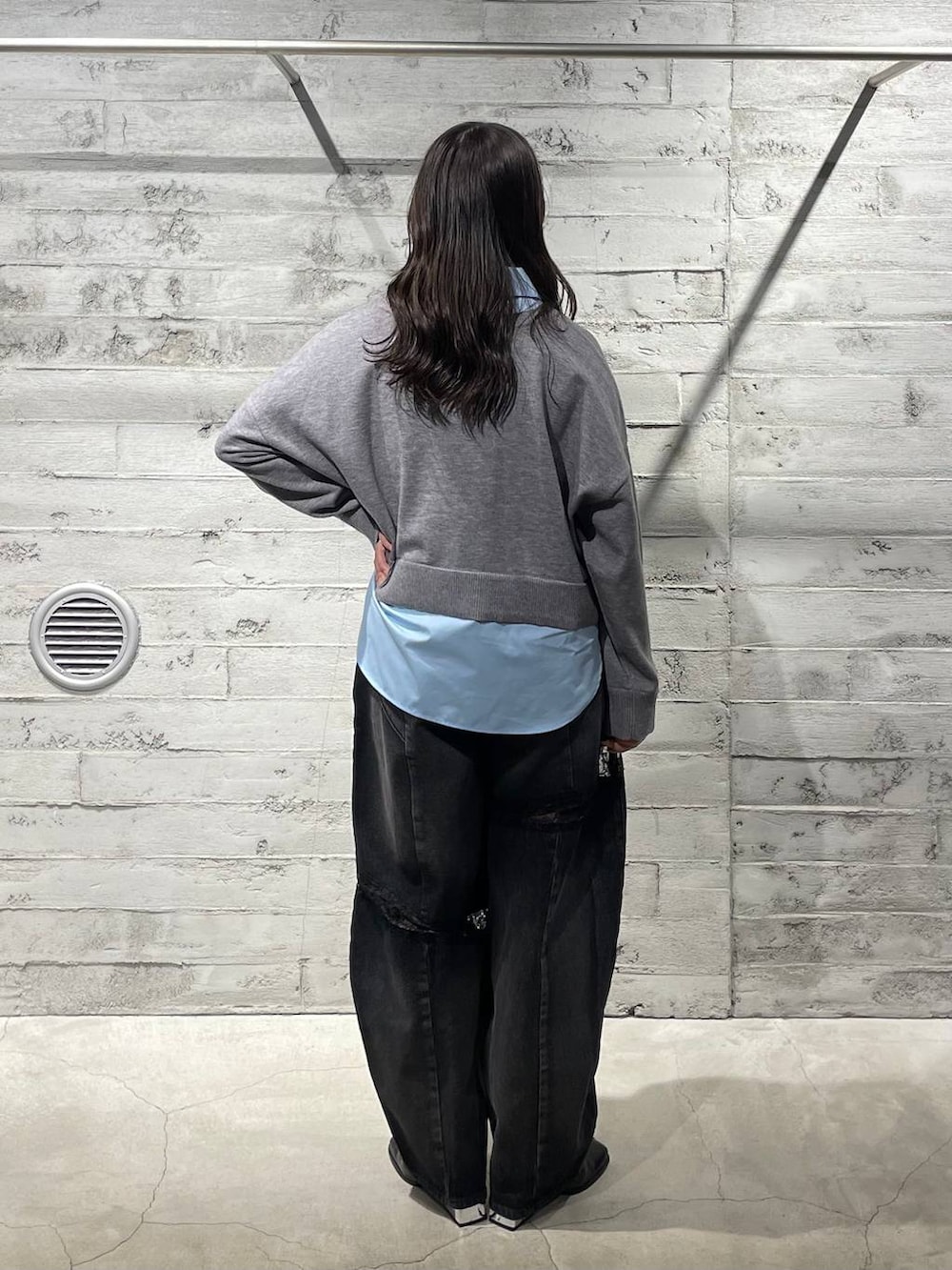 ブラック系のブーツ、ブラック系のデニムパンツ、グレー系のニット/セーターを着用したレディースの冬コーディネートの3枚目の写真