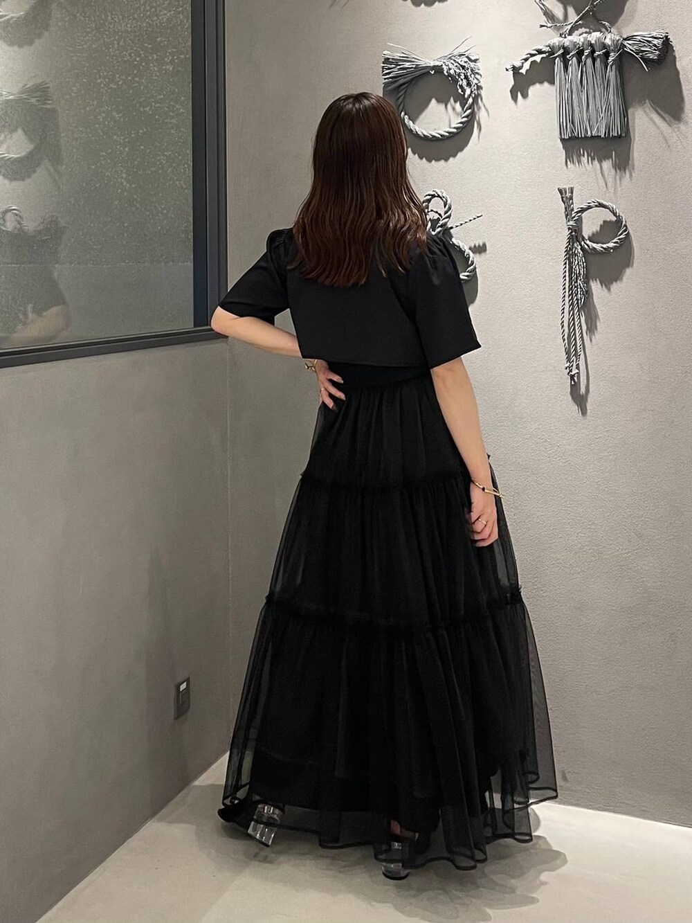 ブラック系のサンダル、ブラック系のワンピース、ブラック系のベルトを着用したレディースの夏コーディネートの2枚目の写真