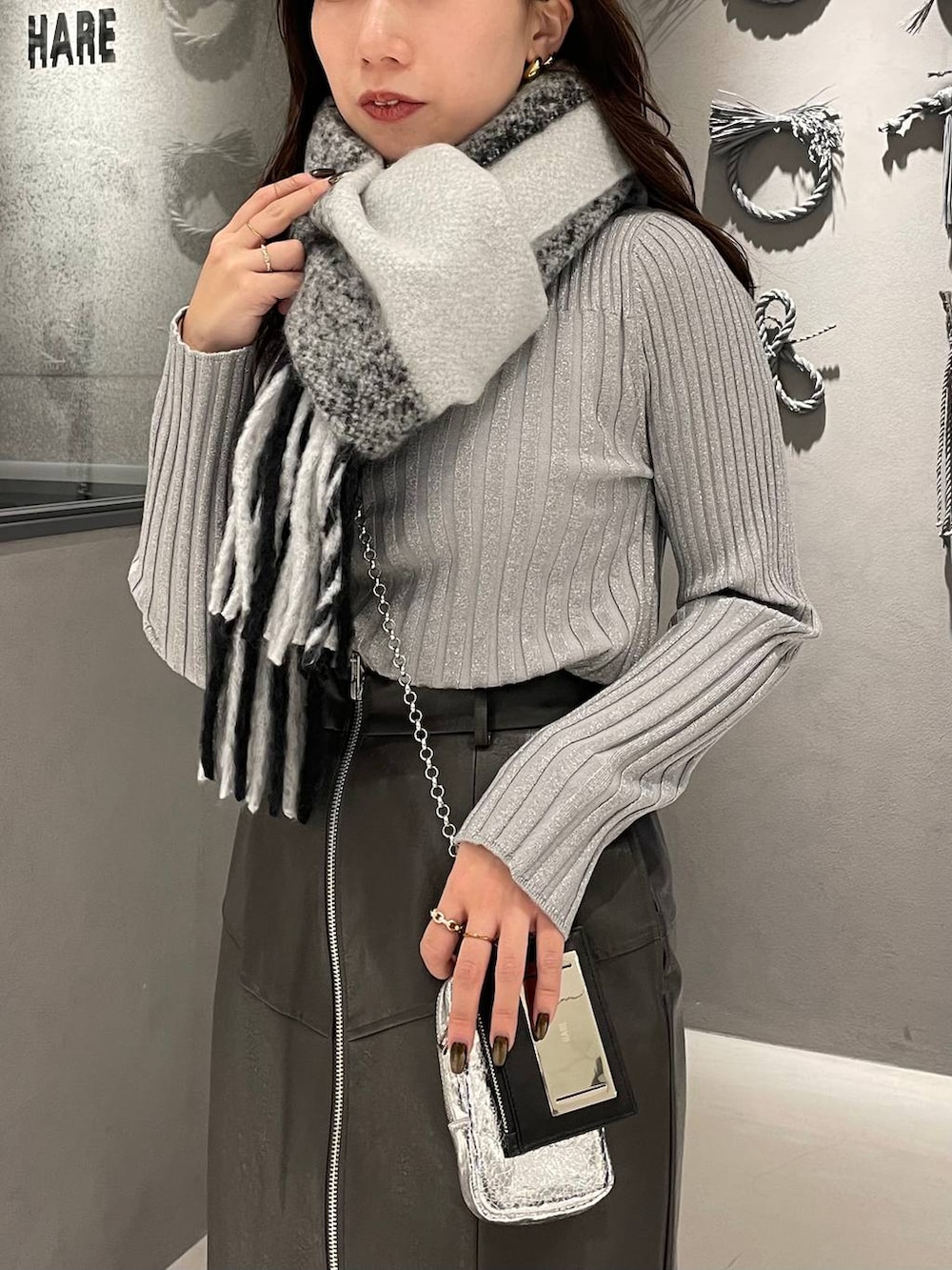 ホワイト系のニット/セーター、ブラック系のブーツ、グレー系のスカートを着用したレディースの冬コーディネートの4枚目の写真