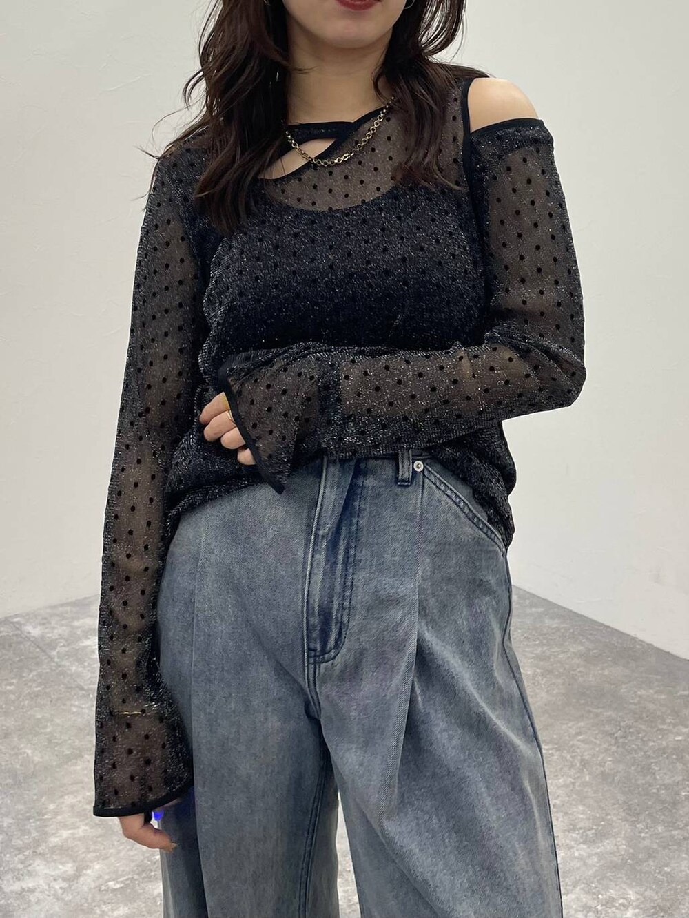 ブラック系のキャミソール、ブルー系のデニムパンツ、ブラック系のサンダルを着用したレディースの夏コーディネートの5枚目の写真