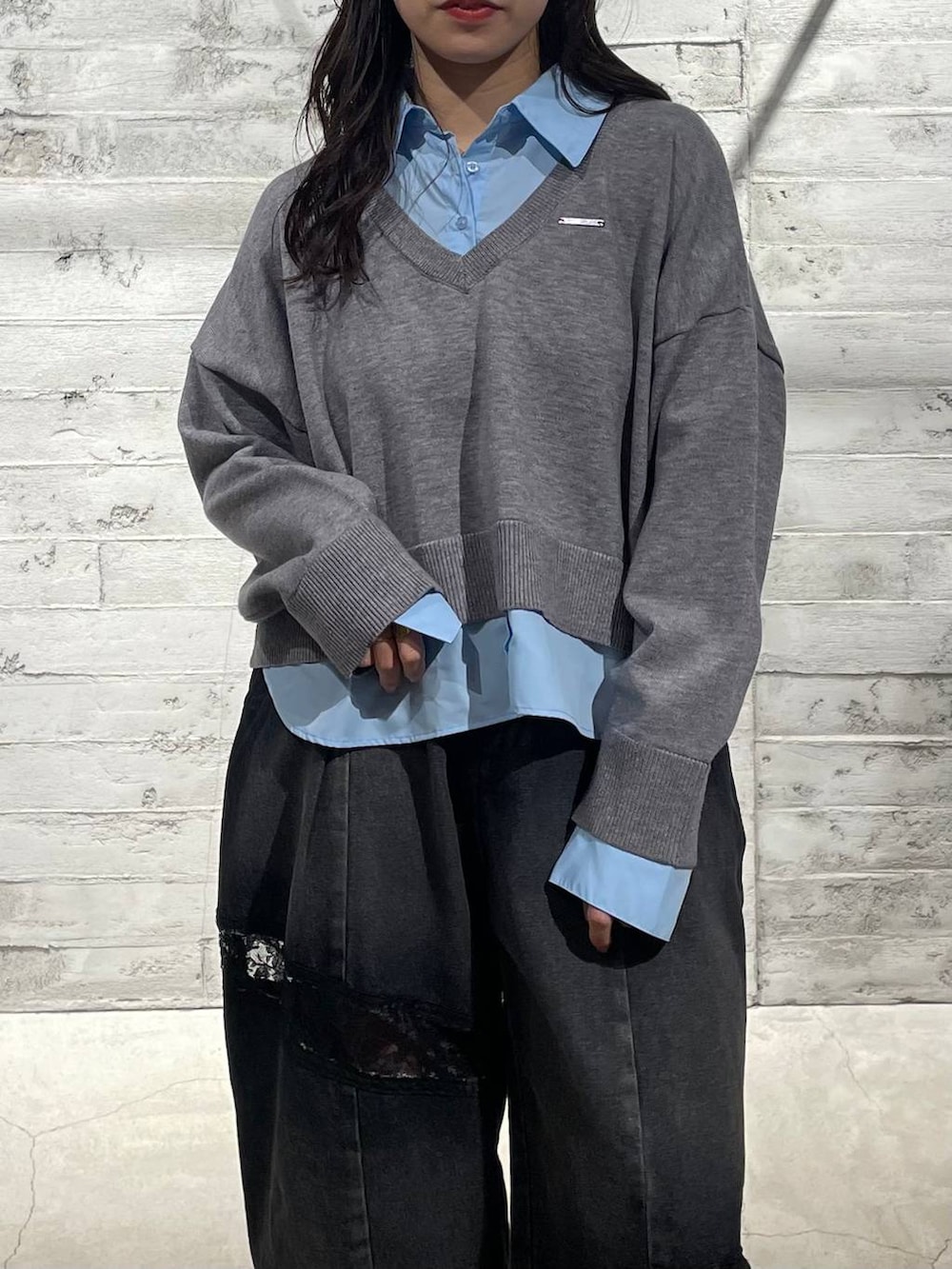 ブラック系のブーツ、ブラック系のデニムパンツ、グレー系のニット/セーターを着用したレディースの冬コーディネートの4枚目の写真