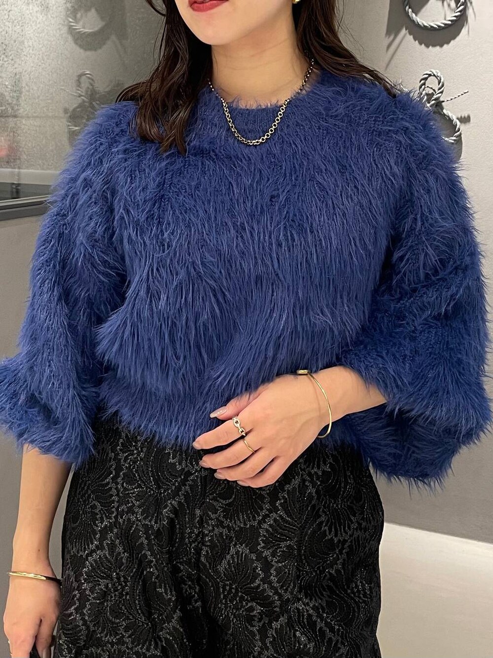 ブルー系のニット/セーター、ブラック系のブーツ、ブラック系のその他パンツを着用したレディースの秋コーディネートの4枚目の写真