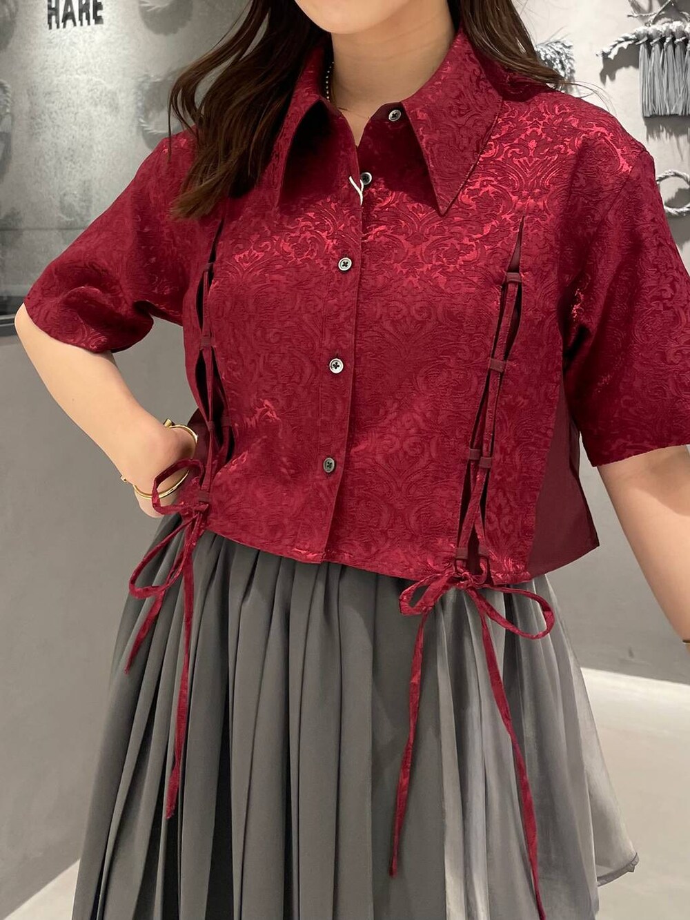 ブラック系のサンダル、レッド系のシャツ/ブラウス、グレー系のスカートを着用したレディースの夏コーディネートの3枚目の写真