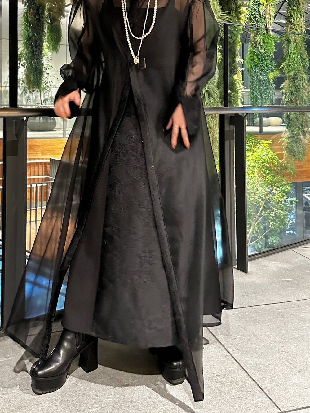 ブラック系のブーツ、ブラック系のドレス、ゴールド系のネックレスを着用したレディースの夏コーディネートの3枚目の写真