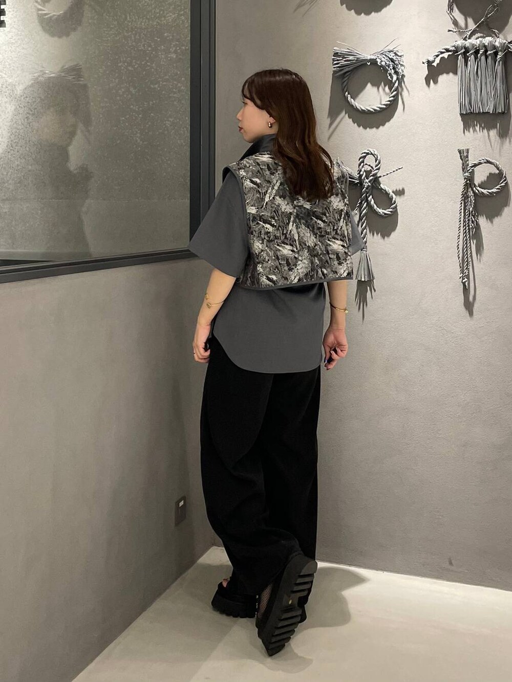 ブラック系のその他パンツ、ブラック系のサンダル、グレー系のシャツ/ブラウスを着用したレディースの春コーディネートの2枚目の写真