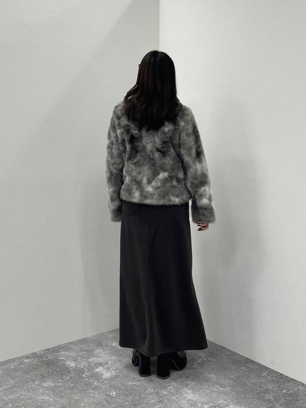 グレー系のブルゾン、ブラック系のブーツ、グレー系のスカートを着用したレディースの秋コーディネートの3枚目の写真