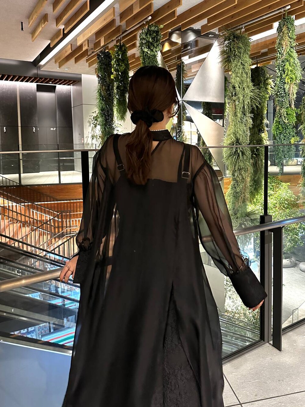 ブラック系のブーツ、ブラック系のドレス、ゴールド系のネックレスを着用したレディースの夏コーディネートの6枚目の写真