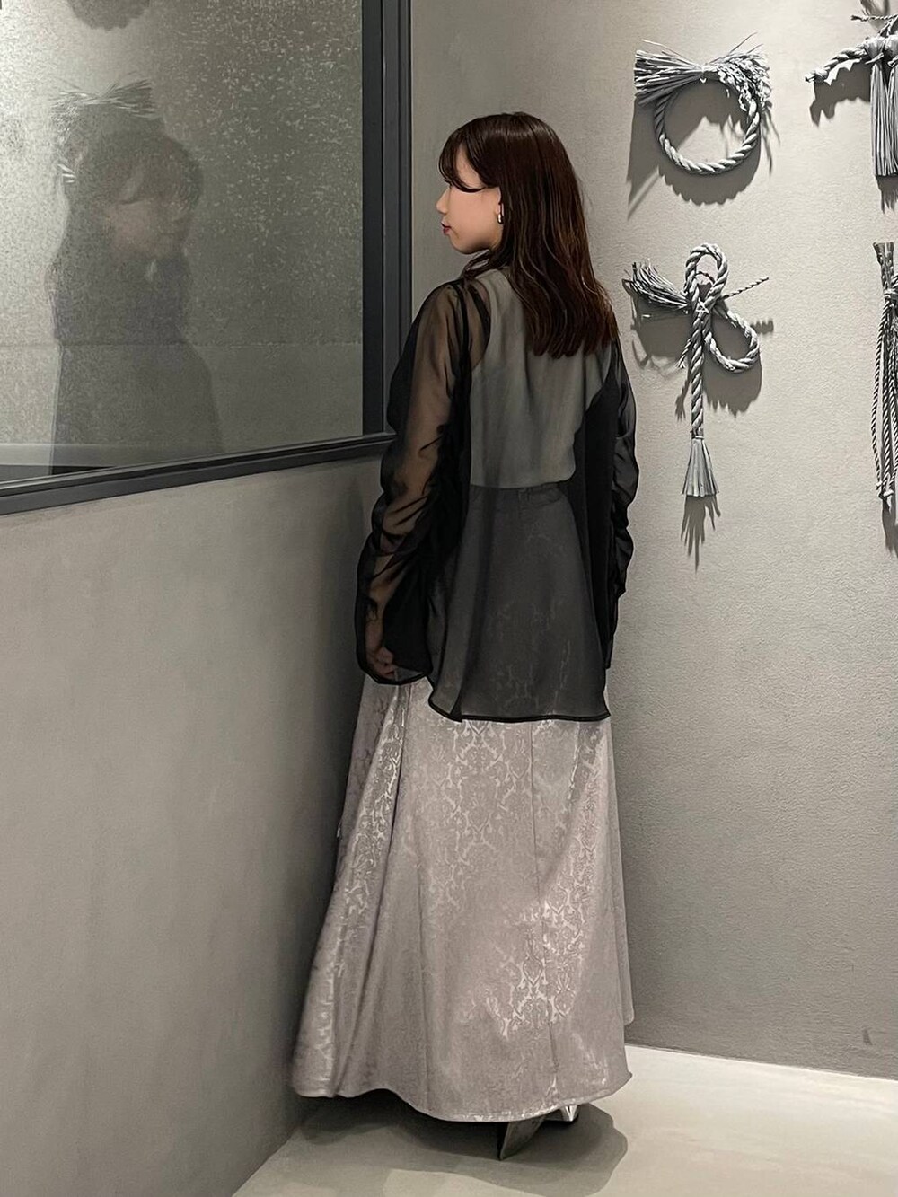 ブラック系のサンダル、グレー系のスカート、ホワイト系のタンクトップを着用したレディースの春コーディネートの2枚目の写真