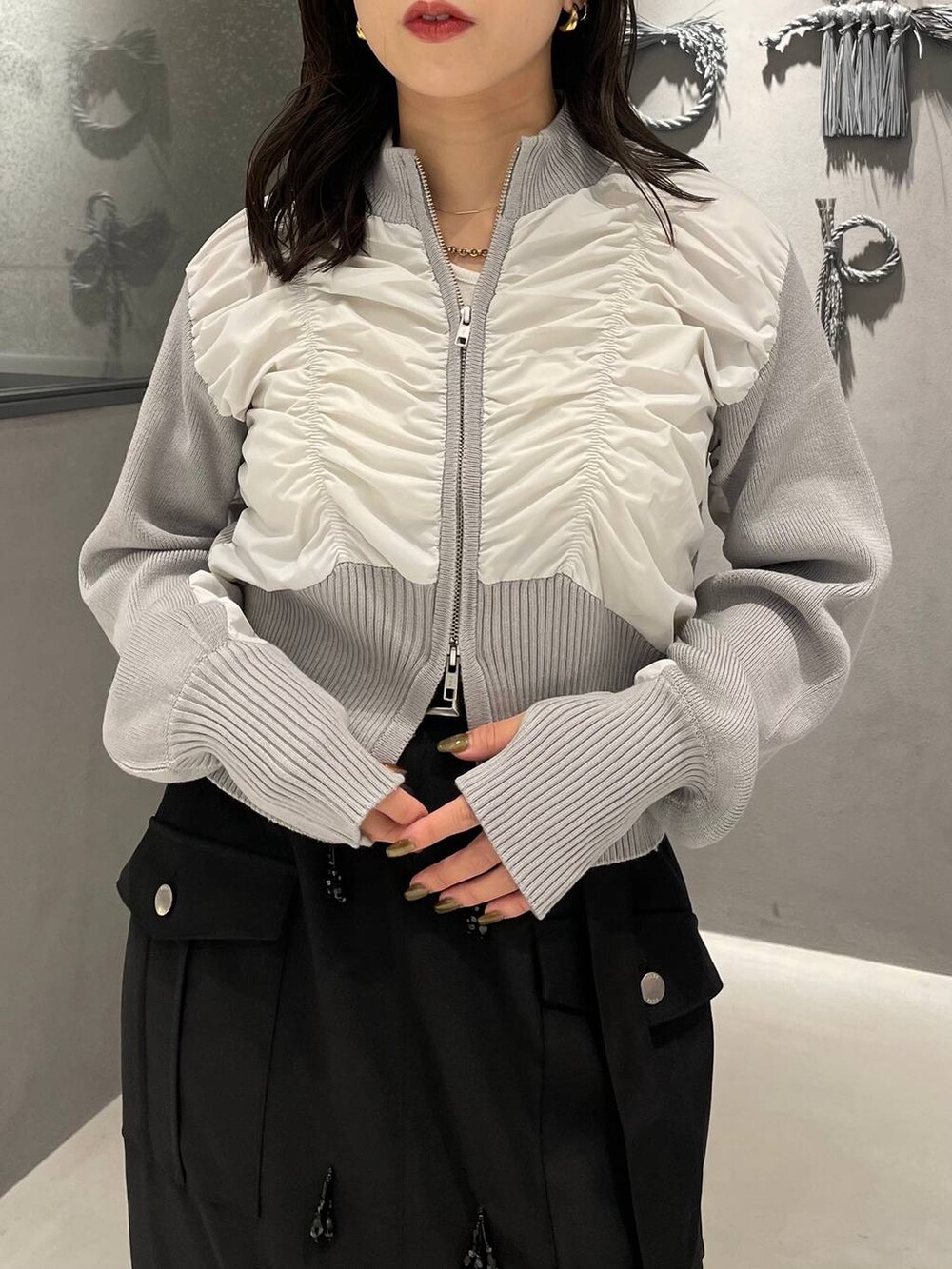 ブラック系のブーツ、ブラック系のスカート、グレー系のニット/セーターを着用したレディースの秋コーディネートの5枚目の写真